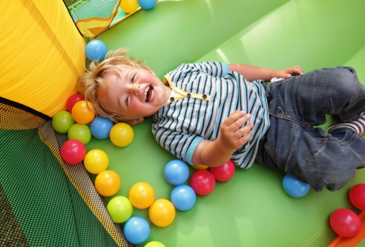 2,Year,Old,Boy,Smiling,On,An,Inflatable,Bouncy,Castle